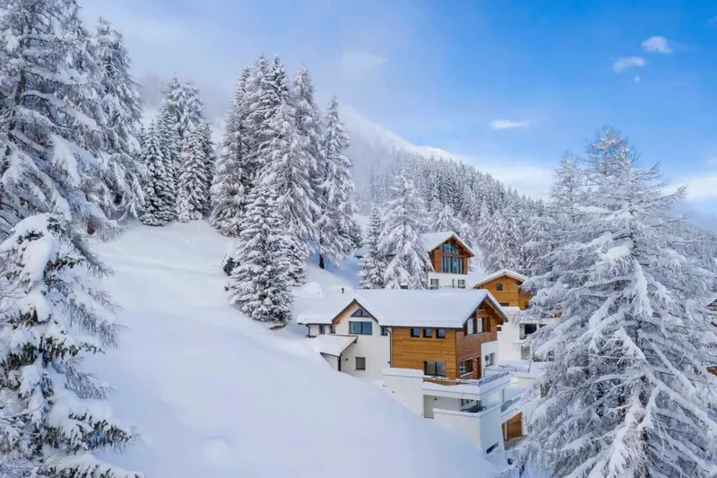 Chalet Kyla in Davos among snow-laden firs
